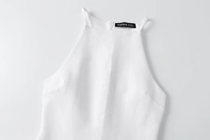 Close-up of a white halter neck dress detailing refined stitching and premium fabric texture