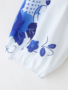 Detail of elastic cuff on white floral short sleeve blouse with blue flower prints