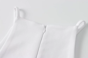 Close-up of white summer dress back with thin straps and hidden zipper detail