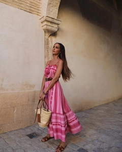 Dettaglio di un abito lungo boho rosa con stampe etniche e cintura marrone in vita