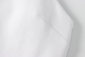 Detail of white halter dress fabric showing twill texture and high-quality stitching