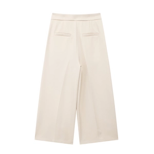 Detail of high-waist beige wide-leg trousers with back welt pockets and sharp creases