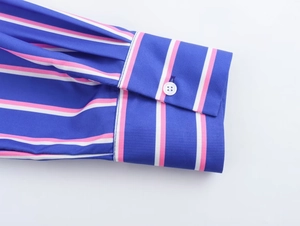 Detail shot of striped shirt cuff featuring blue, pink stripes and a white round button
