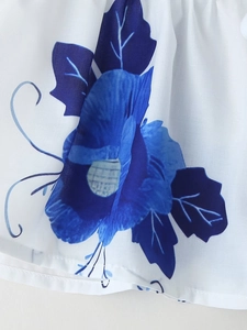 Close-up detail of blue floral print on white summer blouse fabric with clean stitching