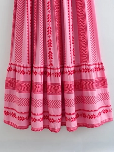 Dettaglio dell'abito boho rosa con stampa geometrica rossa e cucitura sull'orlo a balze