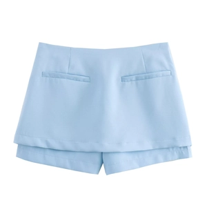 Dettaglio della gonna pantalone celeste con piega frontale e finte tasche simmetriche