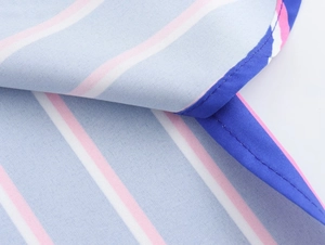 Detail of striped shirt fabric showing precise stitching and light blue cotton texture