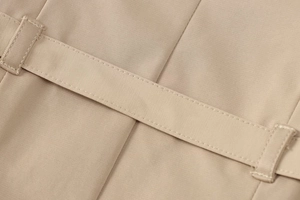 Detaillierte Nahaufnahme der beigen Köperstruktur und Gürtelschlaufen am sommerlichen Kleid