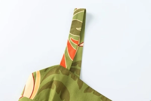 Détail de la bretelle imprimée de feuilles tropicales sur une robe midi vert olive