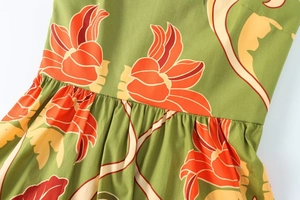 Détail d'une robe midi vert olive à fleurs orange avec design froncé à la taille