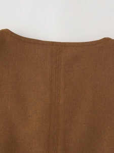 Vue macro détaillée du tissu en lin marron foncé et des coutures précises sur le gilet