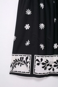 Gros plan sur l'imprimé floral bohème et les détails de la bordure sur la robe midi