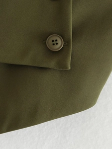 Close-up of olive green twill fabric and a matching dark brown four-hole button detail