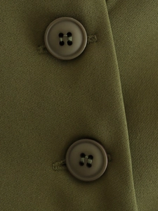 Detail of the olive green twill fabric texture and brown resin buttons on the vest