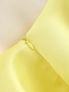 Detailed view of yellow dress fabric with premium matching invisible zipper closure