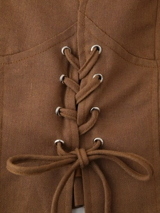 Détail du design à lacets avec œillets métalliques et tissu marron texturé sur la jupe