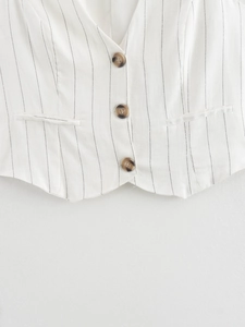 Dettaglio del gilet in lino a righe bianche con scollo a V e bottoni in resina marrone