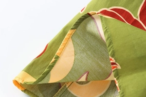 Gros plan d'une robe d'été fleurie verte montrant les détails de couture et du tissu