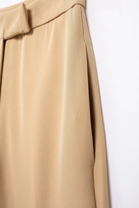 Detail view of khaki high-waisted trousers featuring elegant side pockets and premium fabric
