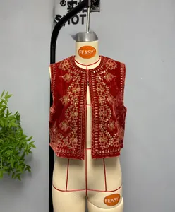 Close-up of red velvet vest with intricate gold embroidery and sequin floral details