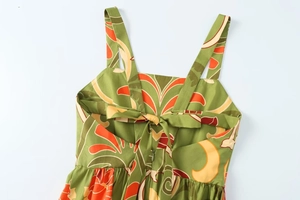 Détail de robe midi à imprimé tropical avec nœud au dos et tissu vert à volants