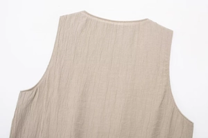 Detailed macro view of the textured vertical ribbed fabric and neckline on a beige top
