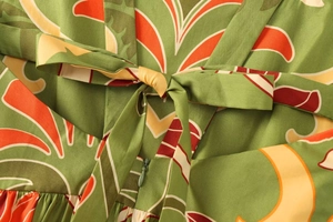Détail d'une robe midi à imprimé tropical avec nœud à la taille et fermeture éclair invisible