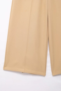 Detail view of khaki wide leg trousers showing clean hem and pressed crease line