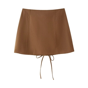 Détail d'une mini-jupe marron taille haute avec coutures symétriques et détails de laçage