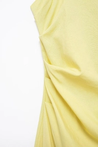 Detail shot of pale yellow gathered fabric showing premium cotton linen texture