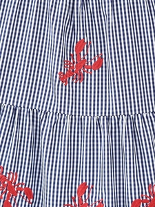 Close-up of blue gingham fabric with exquisite red lobster embroidery detail