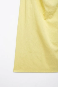 Detail view of light yellow summer midi dress showing fabric texture and smooth stitching