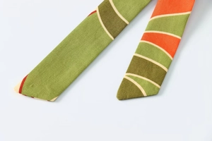 Gros plan détaillé du tissu texturé avec des motifs géométriques ondulés vert et orange