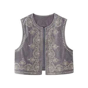 Detail showing intricate gold floral embroidery and sequins on grey velvet vest
