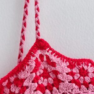 Abito in maglia crochet rosa e rosso con trama a rete e spalline sottili intrecciate
