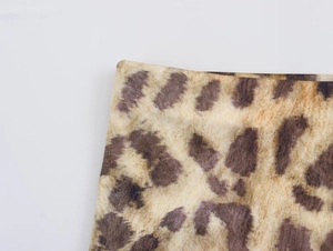 Close-up of high-elastic leopard print fabric with dense brown and black animal texture