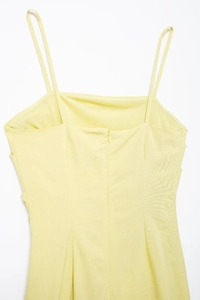 Close-up of light yellow dress back featuring hidden zipper and fine cotton texture