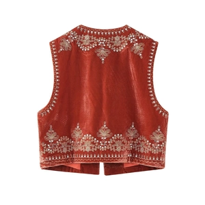 Close-up of gold floral embroidery and sequins on deep red velvet waistcoat back