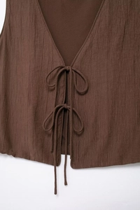 Detailed macro view of dark brown V-neck textured vest with front double-tie closure design