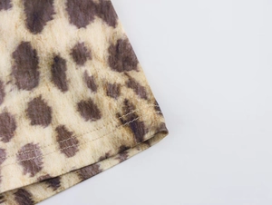 Close-up of leopard print biker shorts showing fine knit texture and double-stitch hem