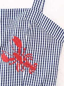 Detail of red lobster embroidery on blue and white gingham summer dress strap