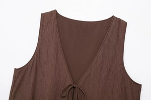 Detail of V-neck brown textured sleeveless top showing crinkle fabric and drawstring