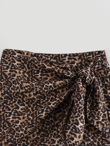 Detail of leopard print cotton wrap skirt with side tie knot and textured fabric