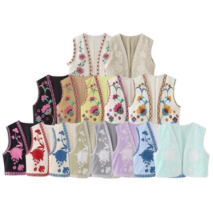 Détail de la broderie florale bohème et du liseré tissé sur des gilets sans manches