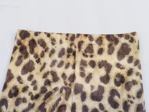 Detailed close-up of leopard print fabric featuring a flexible elastic waistband and stitching