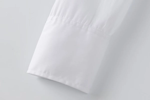 Detail shot of white long sleeve shirt cuff with high-quality twill fabric texture