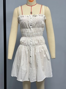 Detail of white cotton smocked camisole dress with pleated texture and front buttons