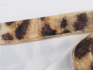 Macro detail of overlock stitching on high-quality leopard print fabric texture
