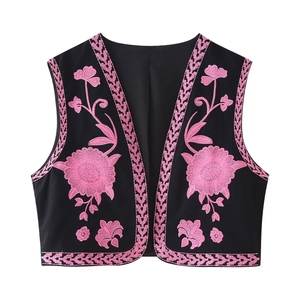 Gros plan de la broderie florale rose et des motifs géométriques sur le gilet noir
