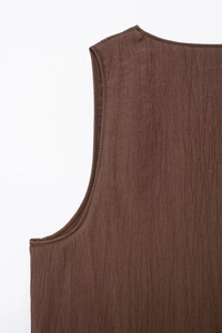 Detailed close-up of dark brown sleeveless top featuring premium vertical pleated texture